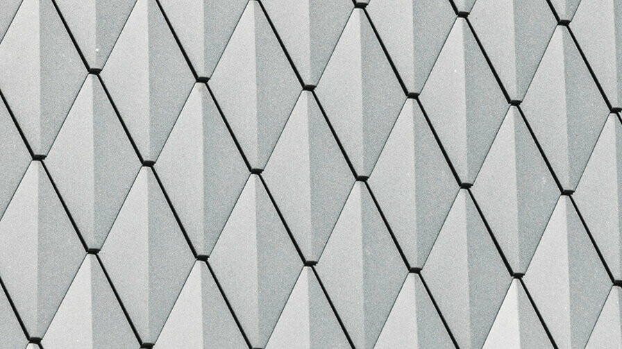 Trapezgaube eines Einfamilienhauses in Mechernich, verkleidet mit kleinen PREFA Dachrauten in P.10 Anthrazit. Das Dach ist mit PREFA Dachschindeln DS.19 in derselben Farbe gedeckt. Die hochwertige Aluminiumverkleidung sorgt für Wetterbeständigkeit und eine moderne, ästhetische Optik.