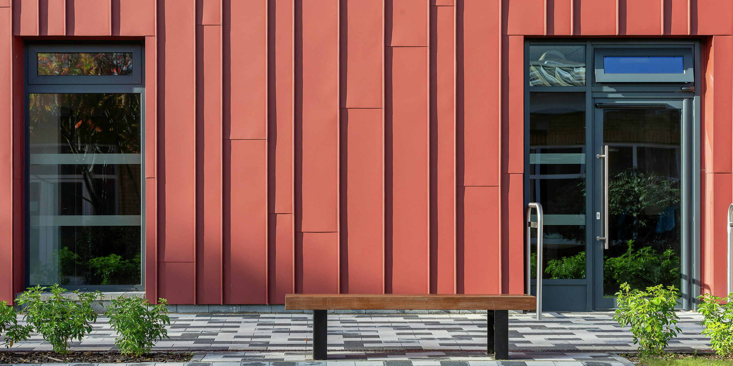 Detailed façade design with PREFALZ: the standing seam cladding with PREFALZ in P.10 oxide red gives the Soldiers' Centre in Pirbright a modern and dynamic appearance. The window and door frames in P.10 anthracite create elegant contrasts, while the precise installation ensures a unique façade interplay. High-quality PREFA aluminium products for long-lasting and aesthetic architecture.