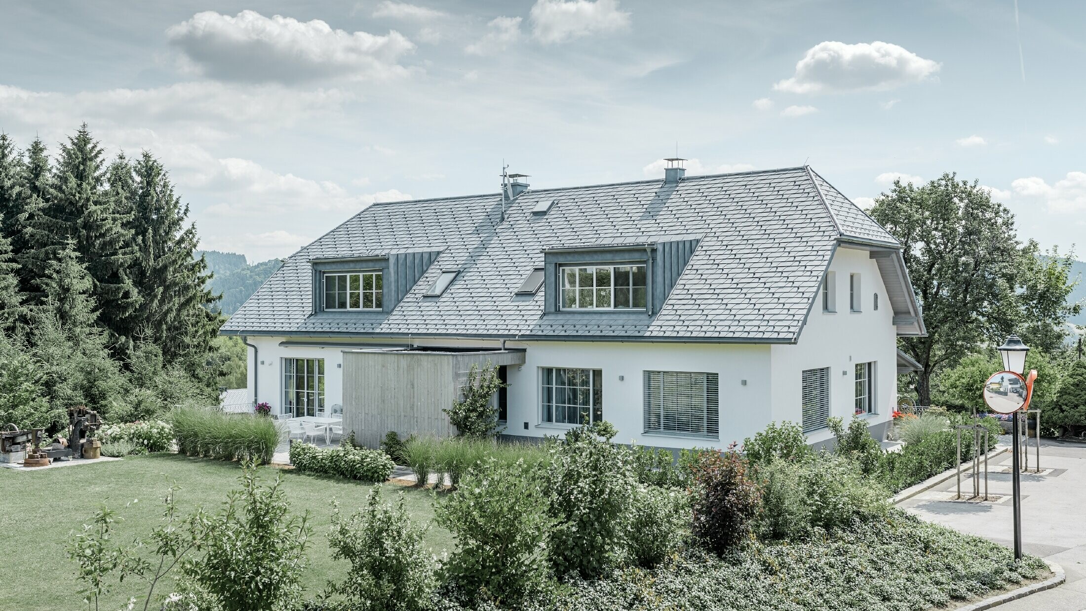 Refurbishment of a half hipped roof with the light PREFA roof shingles in stone grey with two dormers.