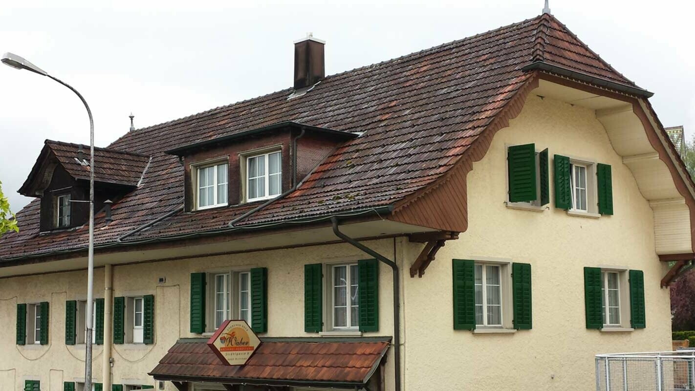 Half-hipped roof before roof renovation with PREFA roof tiles in P.10 anthracite