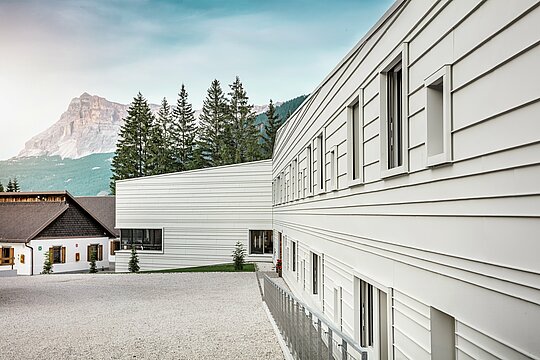 Clear light, sharp lines: the façade of the Tempesti barracks in South Tyrol impressively demonstrates how modern design can blend into the mountain landscape. The horizontal PREFALZ panels in P.10 PREFA white reflect sunlight, improve the microclimate and impress with their robust, long-lasting quality. They are a powerful example of well thought-out military architecture using aluminium.
