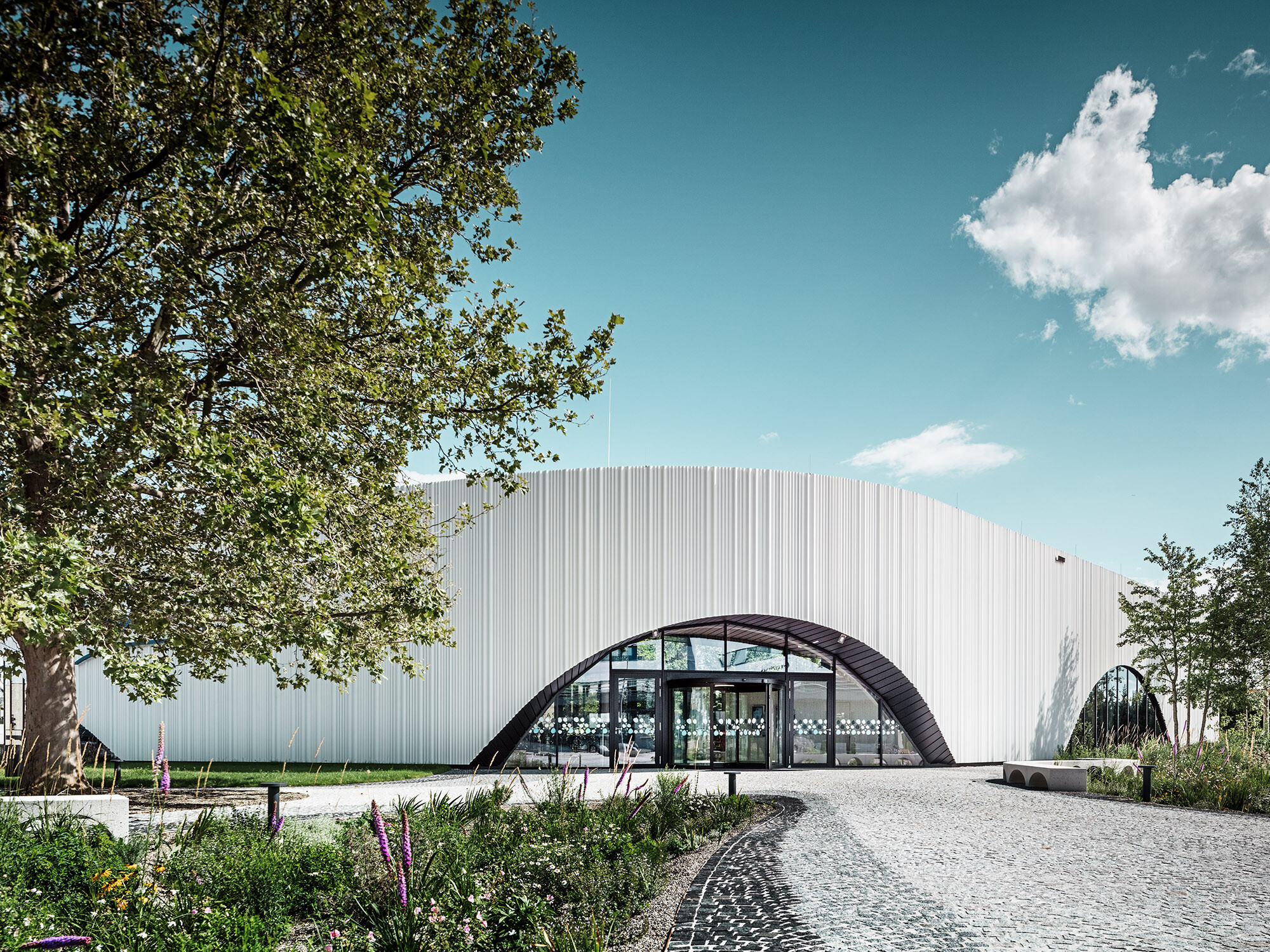 View at Restaurant Walters with one of its arched windows amidst a green environment.