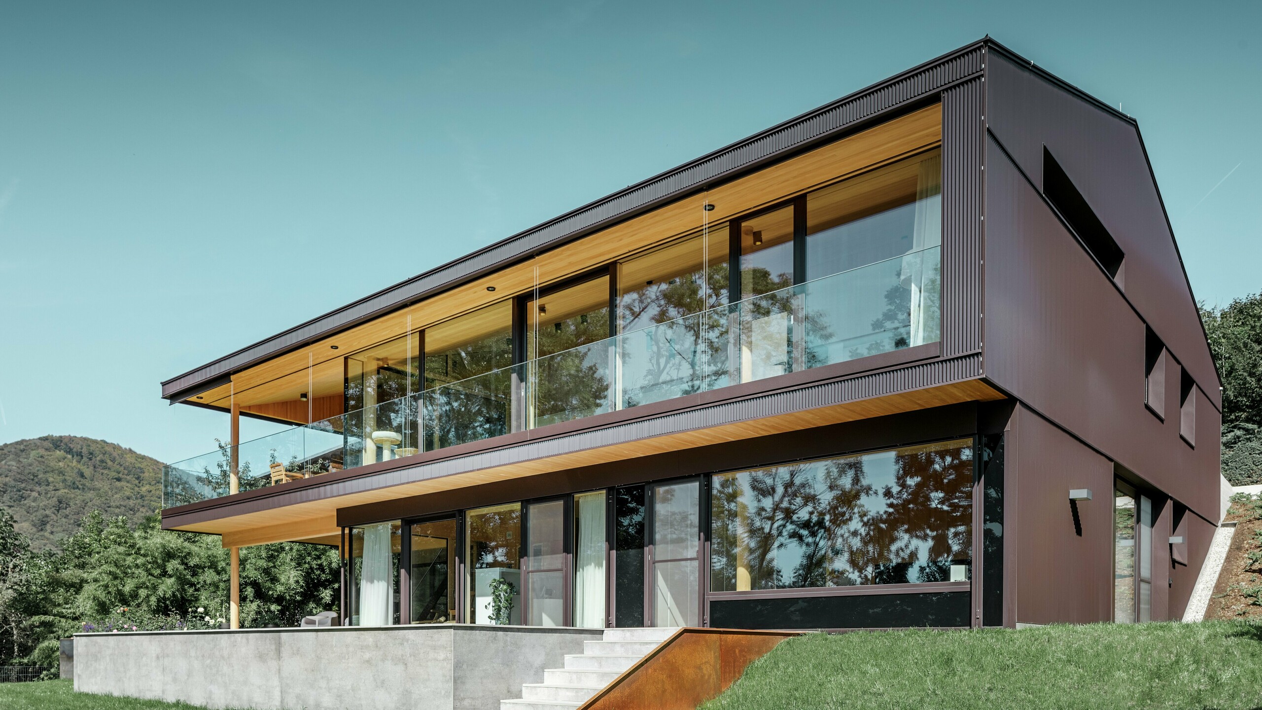 Modern detached house with large windows on the garden side; the façade was clad in the PREFA zig-zag profile in dark brown.