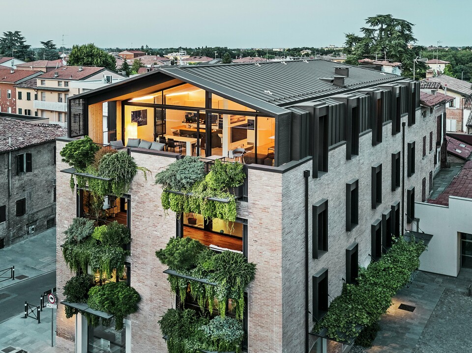 Nachhaltiges Wohnhaus in Italien mit PREFALZ-Aluminiumdach und grüner Ziegelfassade.