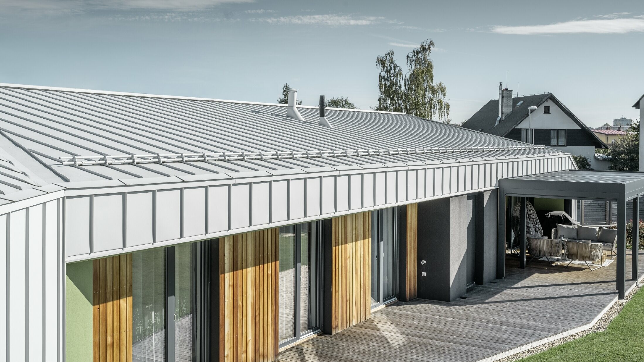 Bungalow with PREFALZ (standing seam) roof and façade in PREFA white and wooden terrace