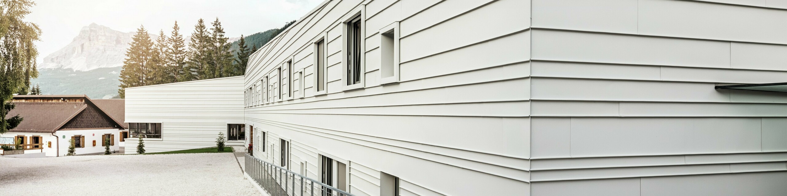 The modern architecture of the Tempesti barracks makes a striking statement with PREFALZ in the colour P.10 PREFA white. The horizontal aluminium panels create a clear structure. The light colour reflects light, which improves the microclimate in the alpine environment.