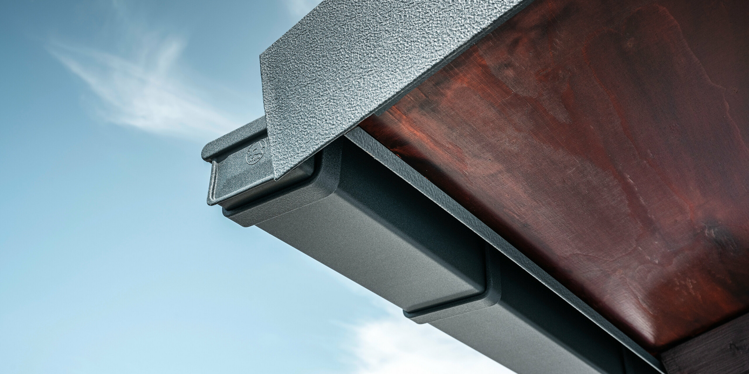 Detailed view of the PREFA roof drainage system in P.10 anthracite on the roof of a detached house in Dortmund.